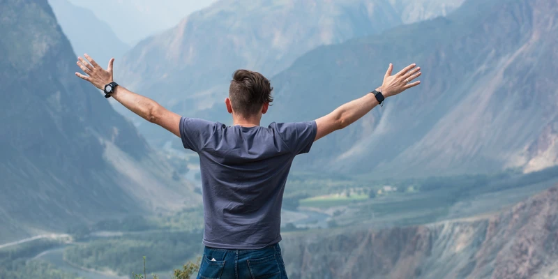 twilight environment man standing top mountain arms outstretched enviroment