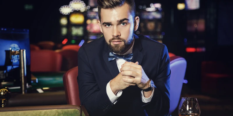 twilight gambling addiction man suit bow tie sitting table