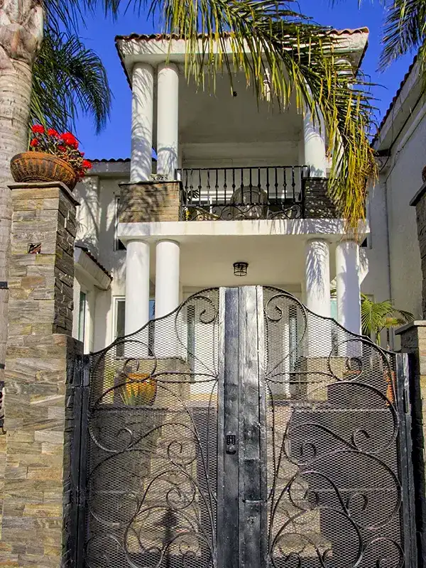 twilight gated entrance house palm trees