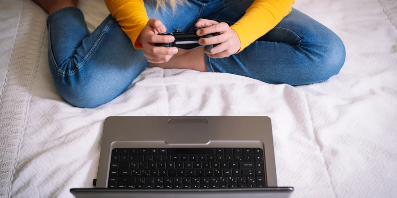 twilight internet addiction woman sitting bed laptop cell