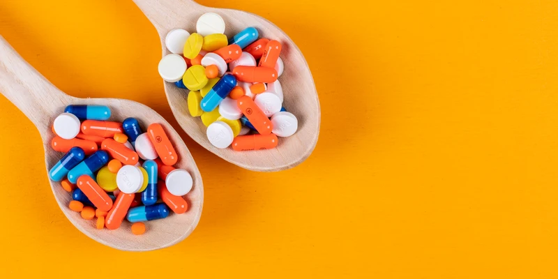 twilight opioid two wooden spoons filled colorful pills orange