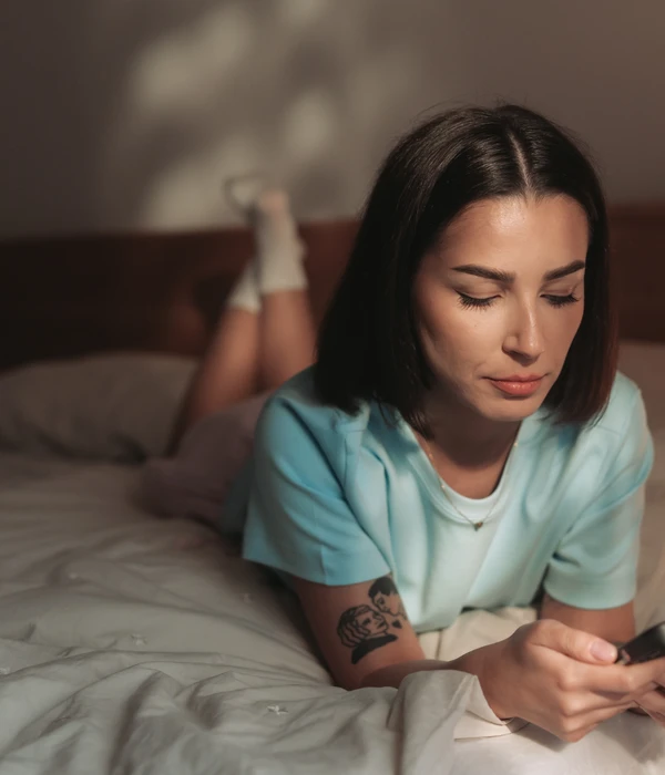 twilight woman laying bed using phone sex porn addiction